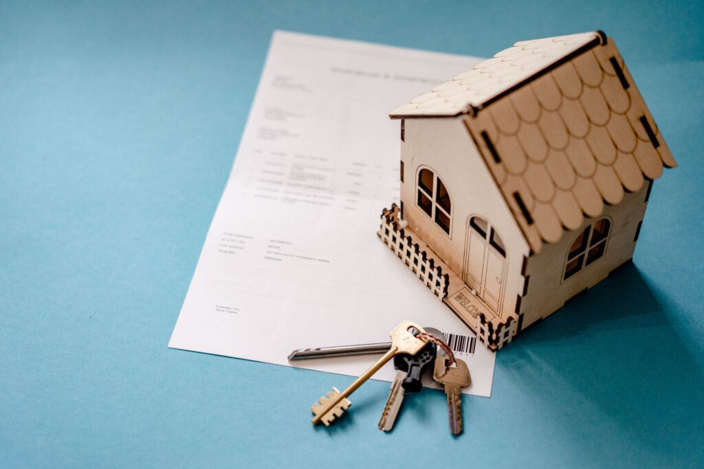 A model house, a set of keys and a signed document — an owner’s title policy protects a Texas buyer’s ownership at closing