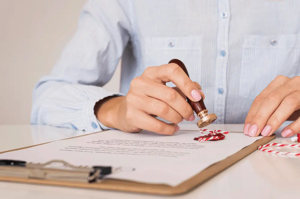 A notary public pressing a seal onto a signed document — a notary acknowledgment is required before a Texas deed can be recorded